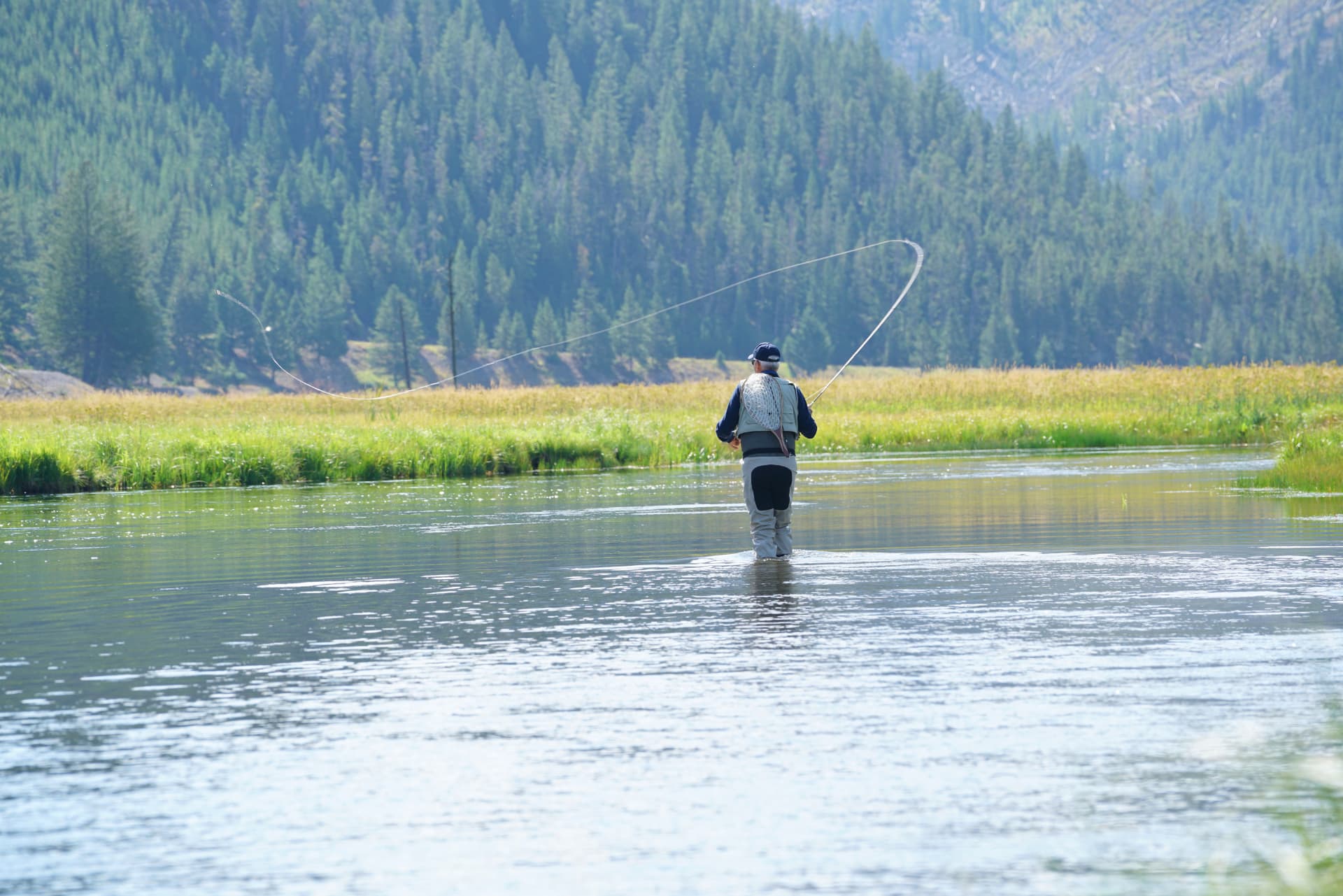 Fly fisherman casting in a Montana river