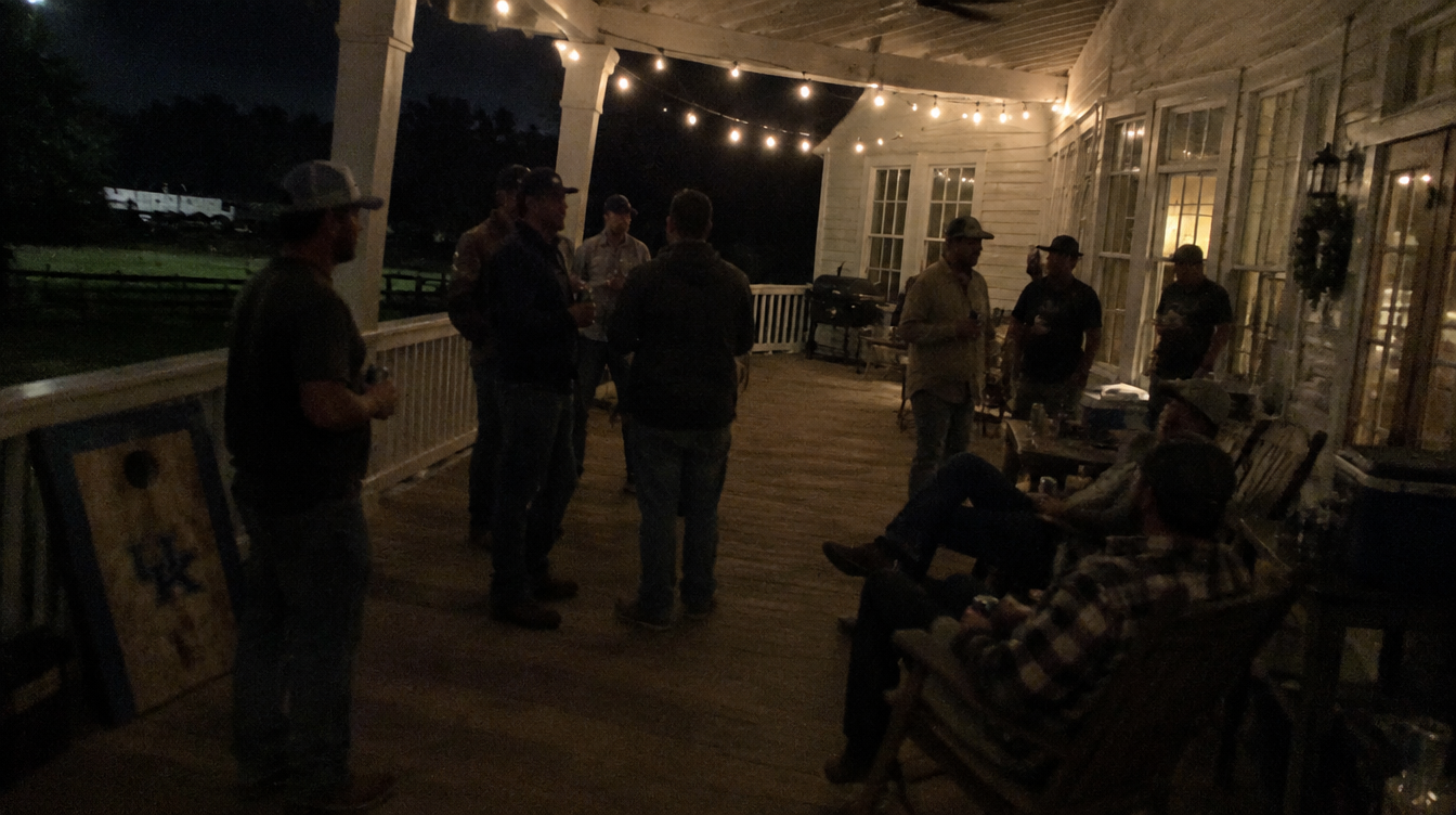 The guys gathered under the string lights on the porch at night