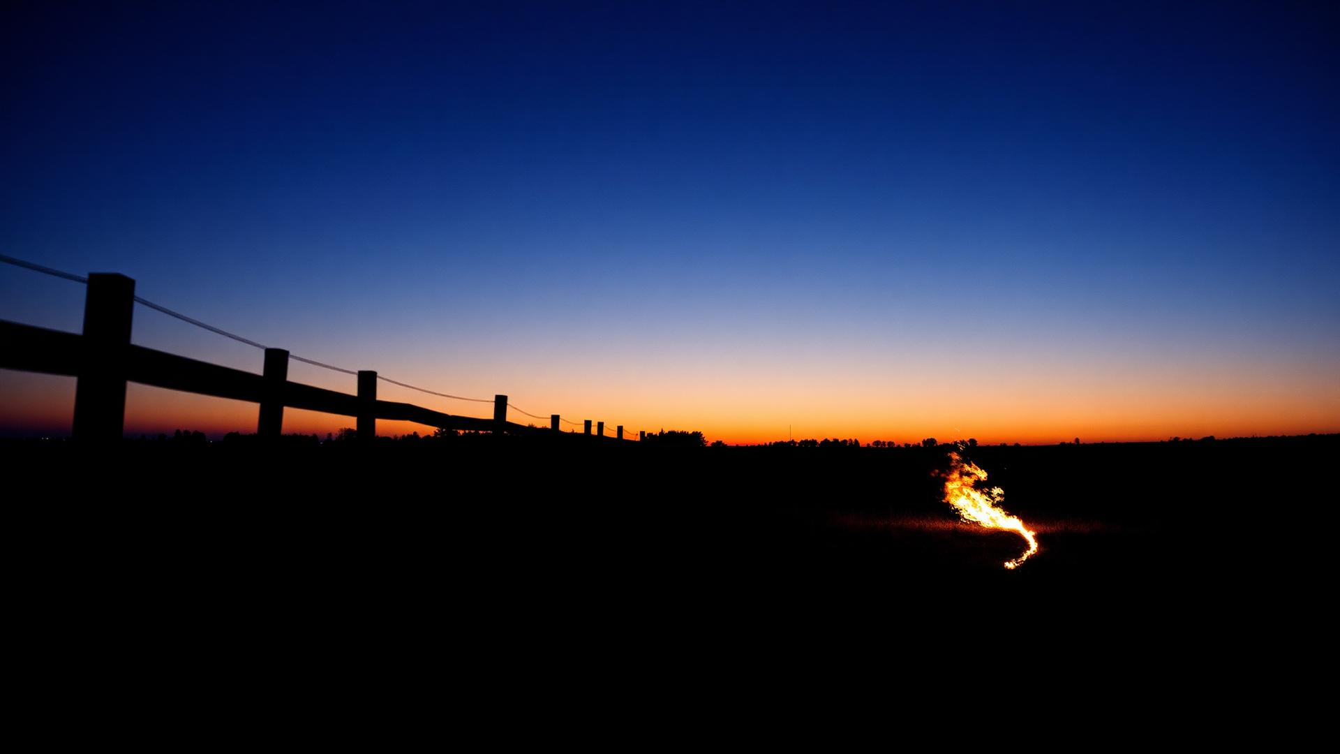 Last light over an open Kentucky field with a fire just started